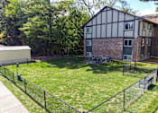 Thumbnail 23 of 25 - A black and white house with a green lawn in front.