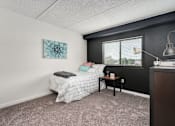 Thumbnail 6 of 25 - A bedroom with a bed, nightstand, and a window.