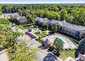 Thumbnail 17 of 25 - A large building complex with a pool and a parking lot.