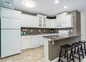 Thumbnail 1 of 25 - A kitchen with white cabinets and a white fridge.