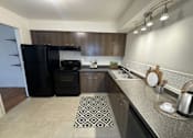 Thumbnail 5 of 7 - a kitchen with a black refrigerator and a sink