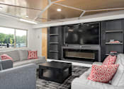 Thumbnail 19 of 25 - A modern living room with a grey couch, a black coffee table, and a black television.