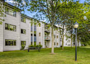Thumbnail 19 of 20 - a large white apartment building with a lawn and trees