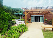 Thumbnail 21 of 27 - A wooden pergola with a bench at Briarlane Apartments in Grand Rapids, MI