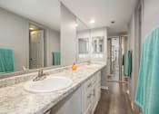 Thumbnail 17 of 34 - A bathroom with a white sink and a mirror.
