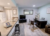 Thumbnail 1 of 34 - A kitchen with a bar area and a couch.