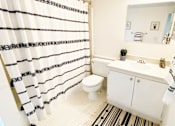 Thumbnail 20 of 22 - a black and white bathroom with a striped shower curtain