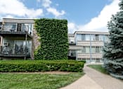 Thumbnail 20 of 20 - A building with a green hedge on the side.
