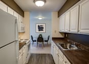 Thumbnail 6 of 20 - A kitchen with white cabinets and a white refrigerator.