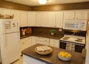 Thumbnail 7 of 20 - A kitchen with white cabinets and a white refrigerator.