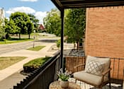 Thumbnail 18 of 20 - A balcony with a chair and a pillow overlooking a street.