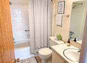 Thumbnail 10 of 12 - a bathroom with a sink toilet and tub and a shower curtain