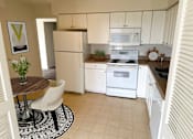 Thumbnail 7 of 12 - a kitchen with white appliances and a dining room table