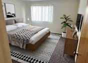 Thumbnail 6 of 12 - a bedroom with a bed and a plant and a tv