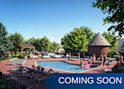 Thumbnail 10 of 26 - A pool area with people relaxing and a gazebo in the background.