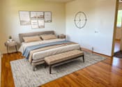Thumbnail 1 of 9 - a bedroom with a bed and a clock on the wall