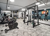 Thumbnail 24 of 26 - a spacious fitness room with cardio machines and weights