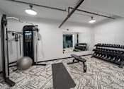 Thumbnail 22 of 26 - a spacious fitness room with cardio machines and weights