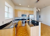 Thumbnail 24 of 50 - a kitchen with black countertops and wood flooring