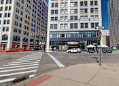 Thumbnail 49 of 50 - a view of a street corner in a large city with a building in the background