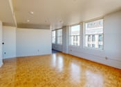 Thumbnail 21 of 50 - a living room with white walls and a wood floor