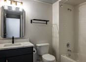 Thumbnail 16 of 50 - a bathroom with a toilet sink and mirror and a bath tub