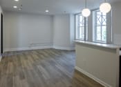 Thumbnail 43 of 50 - a kitchen and living room with white walls and wood floors