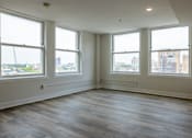 Thumbnail 3 of 50 - an empty living room with wood floors and four windows