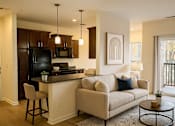Thumbnail 1 of 38 - A kitchen with a black refrigerator and a white couch with blue pillows.