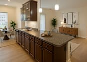 Thumbnail 3 of 38 - A modern kitchen with dark brown cabinets and a granite countertop.