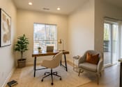 Thumbnail 7 of 38 - A room with a desk, chair, and a potted plant.