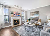 Thumbnail 1 of 26 - a living room with a fireplace and two windows