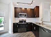 Thumbnail 2 of 26 - a kitchen with black cabinets and stainless steel appliances