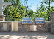 Thumbnail 21 of 26 - an outdoor kitchen with stainless steel appliances and a stone wall