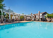 Thumbnail 23 of 26 - a swimming pool with a pergola over it and a house in the background