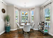 Thumbnail 5 of 26 - a dining room with three windows and a table and chairs