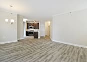 Thumbnail 6 of 26 - an empty living room with a kitchen in the background