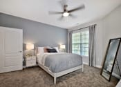 Thumbnail 9 of 26 - a bedroom with a bed and a ceiling fan