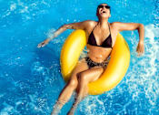 Thumbnail 12 of 22 - a woman in a swimming pool with a yellow raft