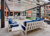 Thumbnail 27 of 35 - Resident courtyard with grills, putting green and hot tub | Vista at the Heights Apartments in Lansing MI