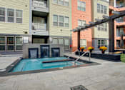 Thumbnail 25 of 35 - Resident courtyard with grills, putting green and hot tub | Vista at the Heights Apartments in Lansing MI