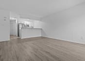Thumbnail 9 of 41 - the living room and kitchen of an apartment with white walls and wood flooring