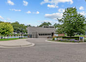 Thumbnail 38 of 50 - a building with a gray roof and a roundabout in front of it