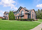 Thumbnail 24 of 26 - A large house with a black iron fence and a green lawn.