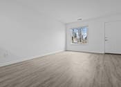 Thumbnail 10 of 41 - an empty living room with white walls and a window