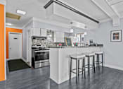 Thumbnail 27 of 38 - a kitchen with a bar with three stools