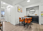 Thumbnail 11 of 21 - a dining room with a table and chairs and a mirror  at Park On Canal Apartments, Michigan