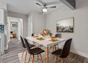 Thumbnail 3 of 12 - A dining room with a table set for four.