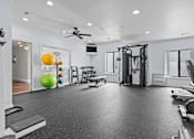Thumbnail 18 of 26 - A spacious home gym with a variety of equipment including a treadmill, weights, and a bench press.