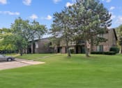 Thumbnail 35 of 44 - an apartment building with a lawn and trees in front of it